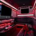 AI-edited party bus interior based on La Buena Vida bus photos, with roses on black leather seating, black TV screens, and softly red-tinted LED strips.